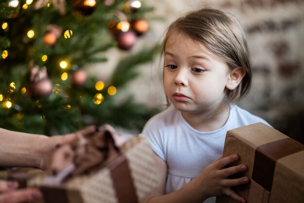 Happy little smiling girl with christmas gift box