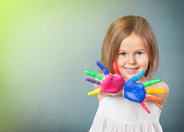 Счастливый ребенок, играющий с красками в пальцах.