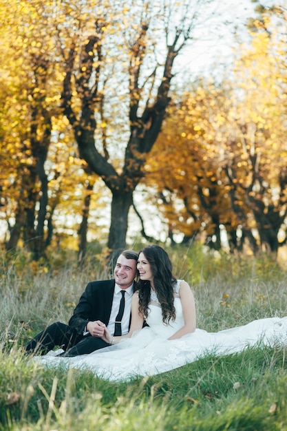 Happy and in love bride and groom in autumn park on their wedding day