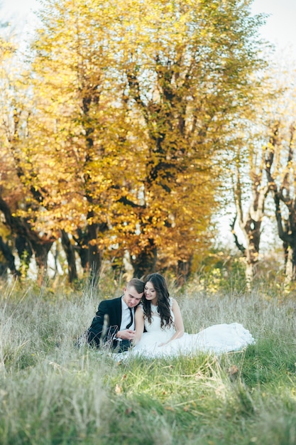 Happy and in love bride and groom in autumn park on their wedding day