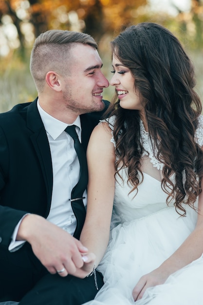 Happy and in love bride and groom in autumn park on their wedding day