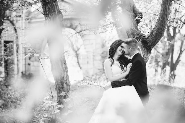 Happy and in love bride and groom walk in autumn park on their wedding day