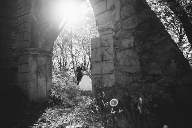 Happy and in love bride and groom walk in autumn park on their wedding day