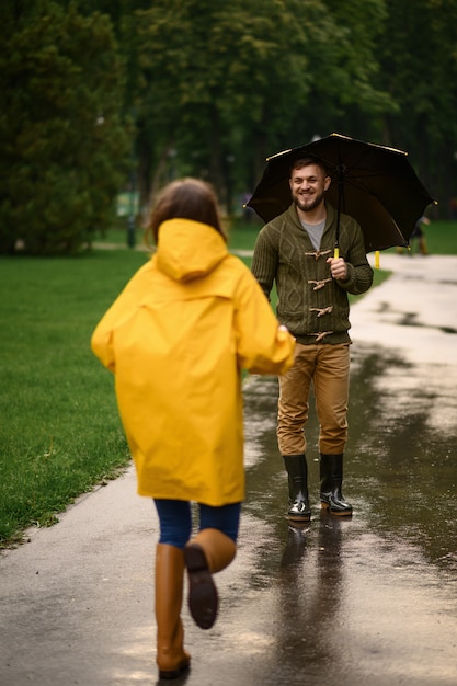 Фото Счастливая влюбленная пара, свидания в парке, летний дождливый день. мужчина и женщина под зонтиком под дождем, романтическое свидание на пешеходной дорожке, сырая погода в переулке