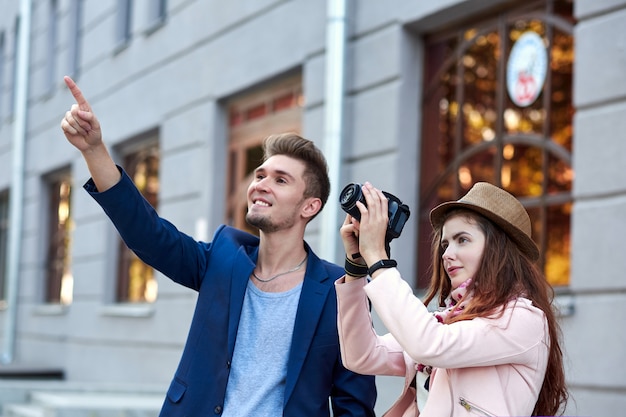 Happy love couple of tourists taking photo on excursion or city tour.