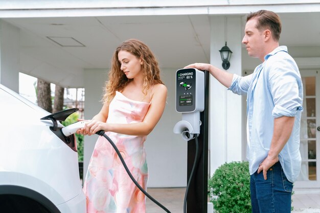 Photo happy and lovely couple recharge ev car at home synchronos