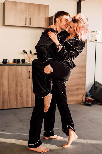 Счастливая любящая пара танцует дома в пижаме