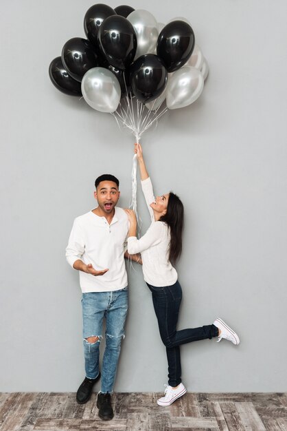 Happy loving couple holding balloons.