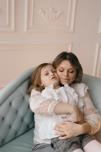 Happy loving family mother and baby girl playing kissing and hugging