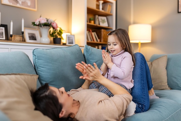 Happy loving family mother and child girl daughter playing kissing and hugging Cute little girl greeting her mother at home Mothers day concept