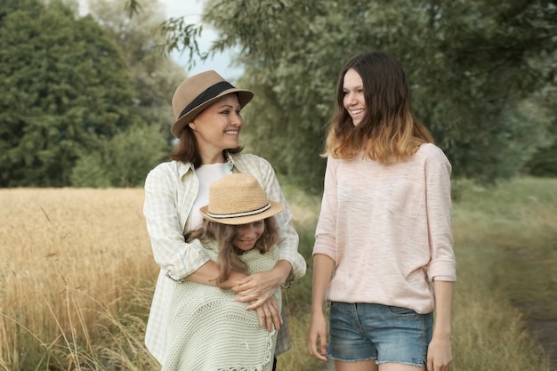 Happy loving family mother and children two daughters walking together