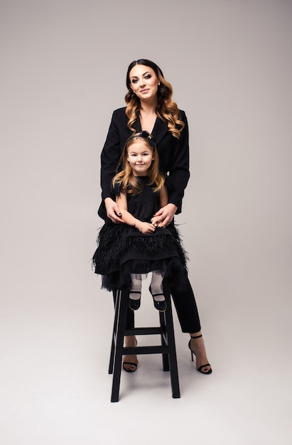 Happy loving family. Mother and her daughter child girl on a gray background