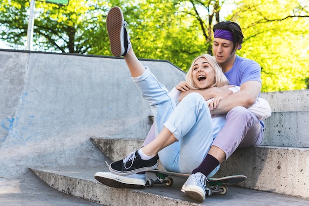 Felice e amorevole coppia di adolescenti in uno skatepark