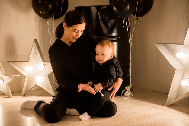 Happy loving young mother kisses her toddler son.