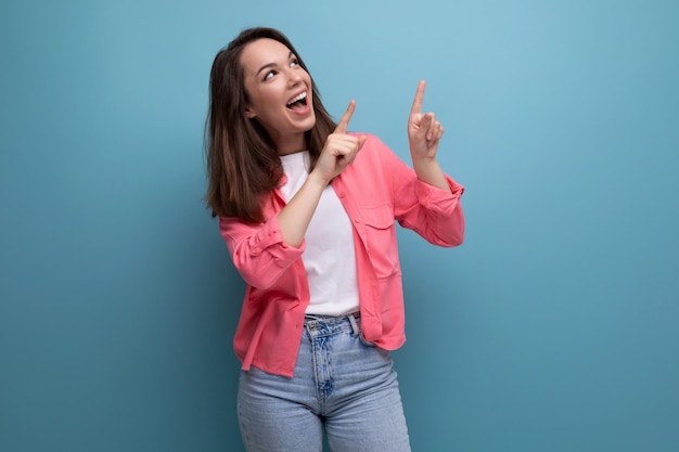 Happy lucky brunette woman in informal look rejoices on studio background