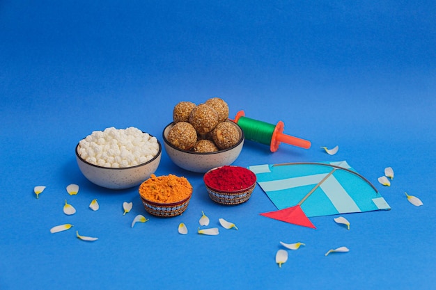 Happy Makar Sankranti, Pongal 및 Uttarayan with Kite, haldi kum kum bowls and tilgul sweets