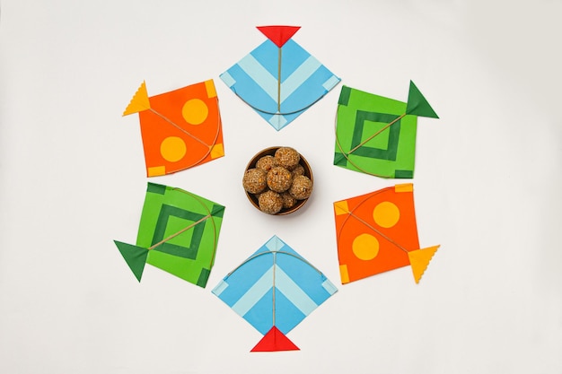 Happy Makar Sankranti, Pongal 및 Uttarayan with Kite, haldi kum kum bowls and tilgul sweets