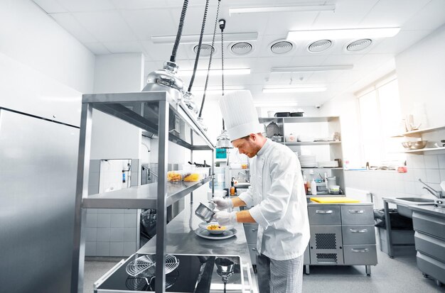 happy male chef cooking food at restaurant kitchen