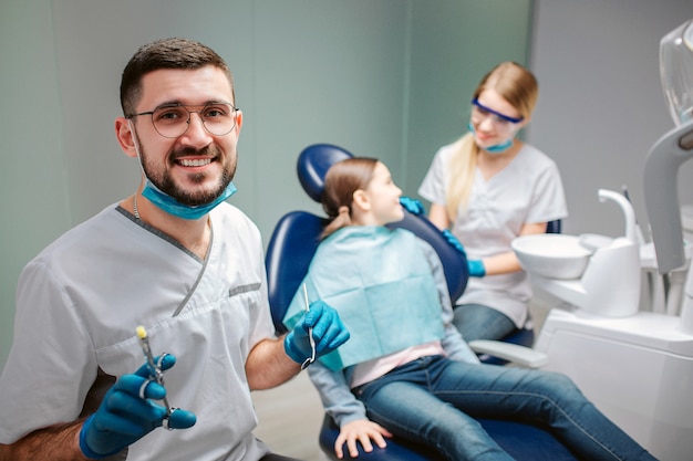 Dentista maschio felice che sorride alla clinica