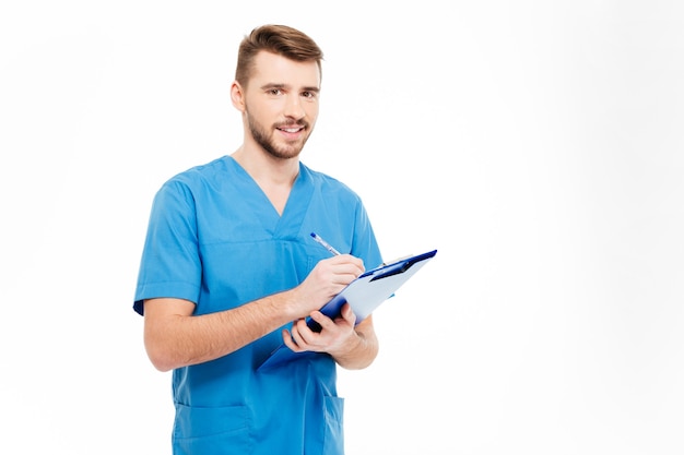 Happy male doctor standing with clipboard isolated on a white background