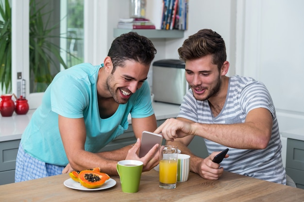 Happy male friends using phone 