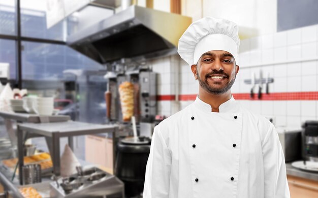 Photo happy male indian chef in toque at kebab shop