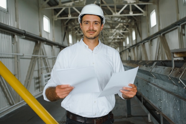 Happy male industrial technician inside a factory