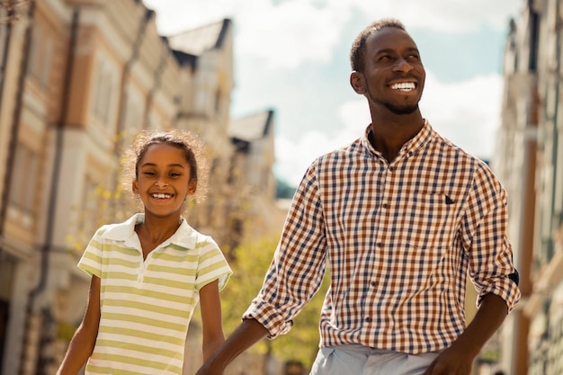 Happy male person enjoying family weekend with his kid