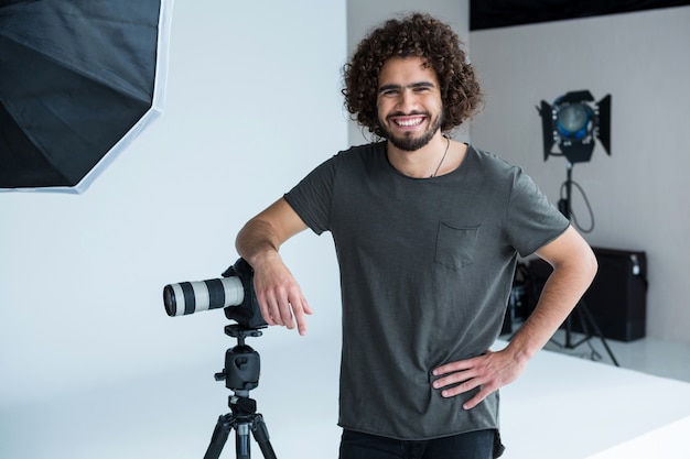 Happy male photographer standing in studio