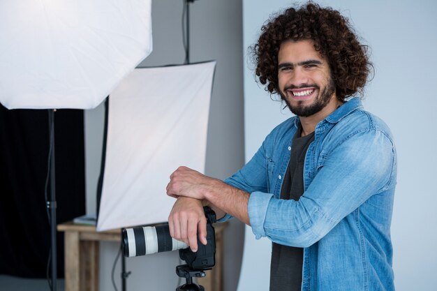 Fotografo maschio felice che sta nello studio