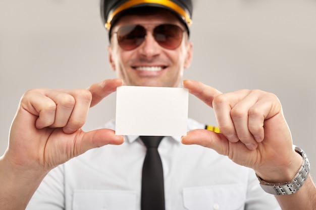 Happy male pilot showing a blank card