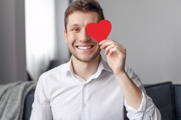 Happy male smiling and holding paper heart