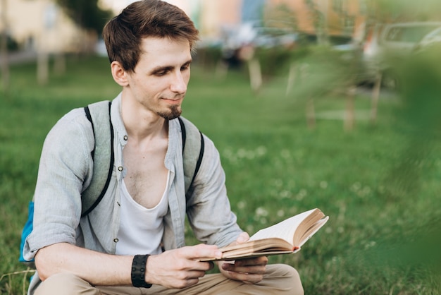 幸せな男の学生は、本を持って読んで