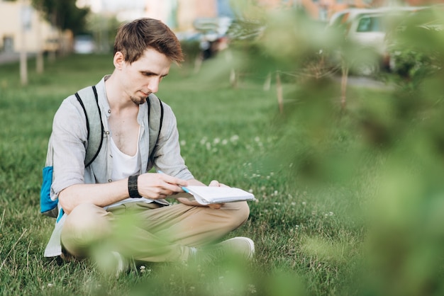 Foto felice studente maschio in possesso di un notebook e sorridente