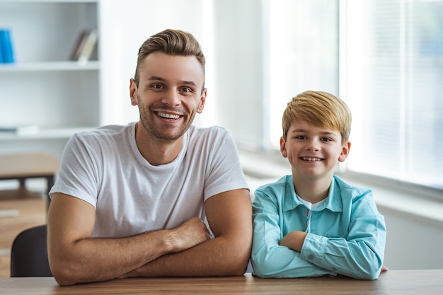 The happy man and a boy sitting at the desk