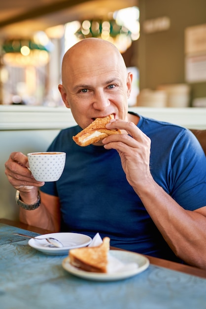 Happy man in a cafe at breakfast