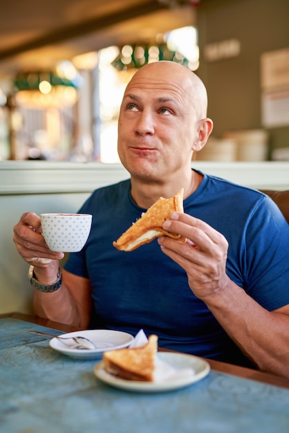 Happy man in a cafe at breakfast