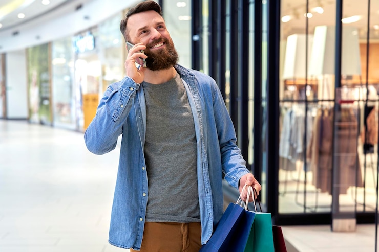 Photo happy man calling while shopping at the mall