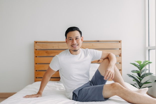 Happy man chilling and relaxed on his bed concept of a healthy mind