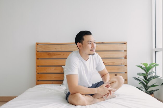 Happy man chilling and relaxed on his bed