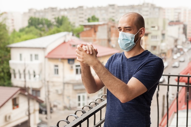 Photo happy man clapping on balcony in support of doctors fighting coronavirus.