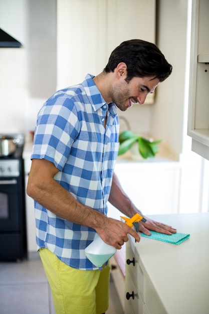 Happy man cleaning the kitchen