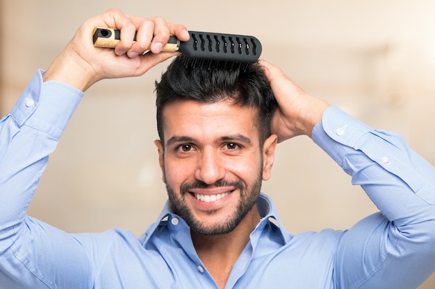 Happy man combing his hair