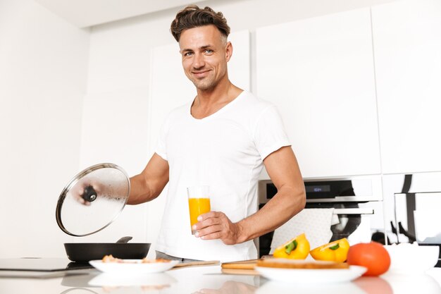 朝食に卵を調理する幸せな男