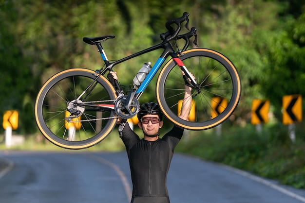 幸せな男サイクリング選手プロ ツアーでの競争のための通りの道路で自転車に乗る