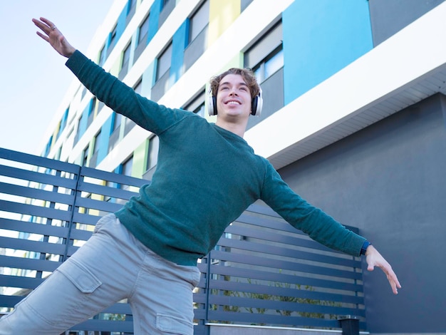 Foto uomo felice che balla mentre ascolta musica in città