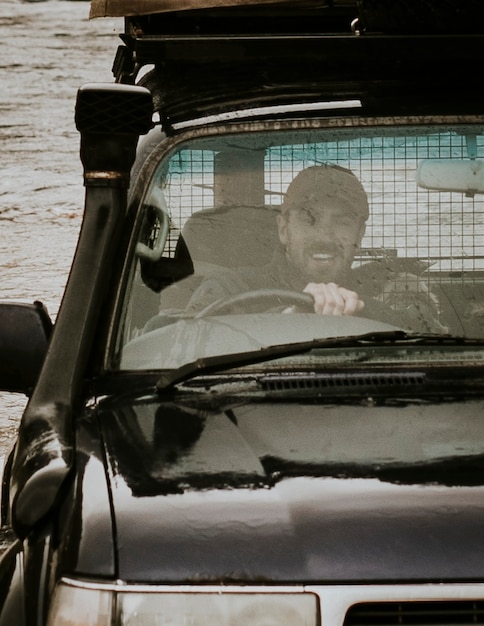 Uomo felice che guida attraverso l'alluvione