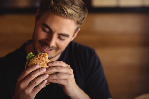 Счастливый человек ест гамбургер