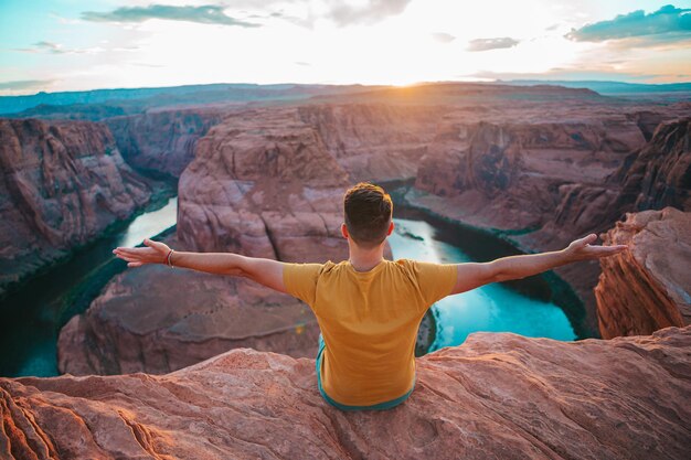 Foto uomo felice sul bordo della scogliera horseshoe bend canyon in page arizona avventura e concetto di turismo