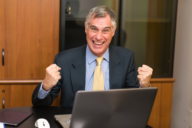 Happy man in front of his laptop computer